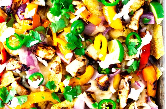 These grilled chicken fajita nachos are beyond delish! Chicken, peppers, and onions all grilled to perfection then topped on top of tortilla chips with cheese and optional toppings have these nachos out of this world! 